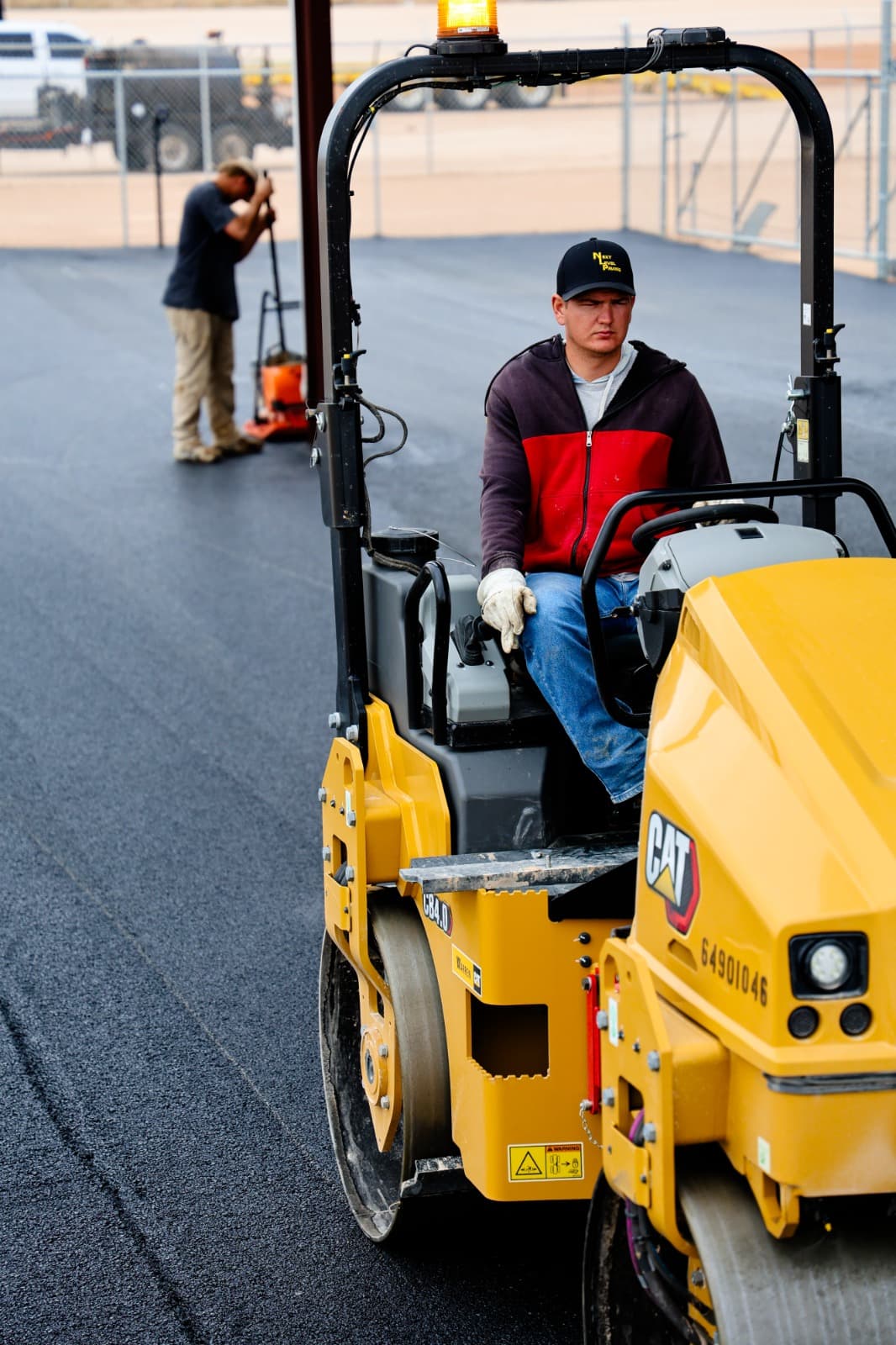 Next Level Paving compactor operator on fresh asphalt paving project